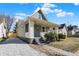 Charming home with light siding, white brick accents, covered porch, and gravel driveway at 39 S Holmes Ave, Indianapolis, IN 46222