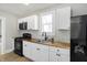 Modern kitchen features white cabinets, butcher block countertops, and black appliances at 39 S Holmes Ave, Indianapolis, IN 46222