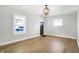 Spacious living room with hardwood floors, white walls, and decorative light fixture at 39 S Holmes Ave, Indianapolis, IN 46222