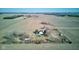 An aerial view displays a country home, green shed, and farm fields set among a landscape under a bright sky at 4254 N 200 W, Greenfield, IN 46140