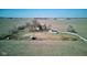 Aerial view of a charming farmstead featuring a white house and green outbuilding surrounded by expansive fields at 4254 N 200 W, Greenfield, IN 46140