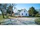 Quaint country home with a green roof, surrounded by mature trees, and a gravel driveway at 4254 N 200 W, Greenfield, IN 46140