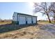 Three-car garage with ample space for vehicles, equipment and storage, next to a gravel drive at 4254 N 200 W, Greenfield, IN 46140