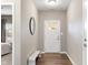 Modern entryway with a white front door, bench seating, sleek mirror, and stylish wood flooring at 4313 W Hidden Preserve Cv, New Palestine, IN 46163