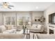 Inviting living room with fireplace, large windows offering backyard views, and comfortable neutral furniture at 4313 W Hidden Preserve Cv, New Palestine, IN 46163