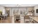 View of open floorplan with dining table and living area with hardwood floors and lots of light at 4313 W Hidden Preserve Cv, New Palestine, IN 46163