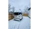 Airstream trailer in the backyard of this home sits in the snow, surrounded by a wood fence at 632 N Temple Ave, Indianapolis, IN 46201