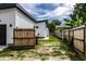 Backyard view between the modern detached garage and fence with grassy area at 632 N Temple Ave, Indianapolis, IN 46201