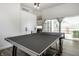 Open game room space features a ping pong table, modern lighting, and access to a patio at 632 N Temple Ave, Indianapolis, IN 46201