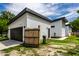 Modern detached garage with white siding and a black garage door sits on a manicured lawn at 632 N Temple Ave, Indianapolis, IN 46201