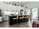 Stylish kitchen featuring white cabinets, stainless steel appliances, and a black island with bar seating, offering a modern design at 632 N Temple Ave, Indianapolis, IN 46201