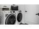 Modern laundry room with front load washer and dryer with a black door at 632 N Temple Ave, Indianapolis, IN 46201