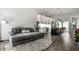 Open layout living space with a plush couch next to a modern kitchen with white cabinets and stainless steel appliances at 632 N Temple Ave, Indianapolis, IN 46201