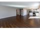 Open-concept living area with hardwood floors, seamlessly connecting the living room, staircase, and kitchen at 6513 Kingsbury Way, Zionsville, IN 46077