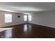 Spacious living room with hardwood floors and three large windows providing ample natural light at 6513 Kingsbury Way, Zionsville, IN 46077