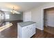 Open living space featuring hardwood floors, a kitchen island, and seamless transition to the living room at 6513 Kingsbury Way, Zionsville, IN 46077