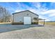 View of a large outbuilding, with a covered lean-to, and a gravel driveway. Storage and covered work area at 725 E County Rd 600 N, Pittsboro, IN 46167