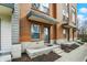 View of the townhome entrances, each featuring a covered porch and updated landscaping that welcomes visitors at 805 Switchyard Pl, Indianapolis, IN 46202