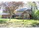 A backyard featuring a patio with blue umbrellas, a swing set, and lush landscaping at 8220 Traders Hollow Ct, Indianapolis, IN 46278