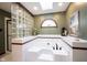 Beautiful bathroom showcasing a large tub with tile accents, a skylight, and elegant fixtures at 8220 Traders Hollow Ct, Indianapolis, IN 46278