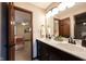 Bathroom with a double sink vanity, bronze fixtures, and a neutral color scheme viewed from open doorway at 8220 Traders Hollow Ct, Indianapolis, IN 46278
