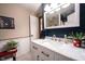 Updated bathroom featuring a marble countertop vanity, custom mirror, and white wainscoting at 8220 Traders Hollow Ct, Indianapolis, IN 46278