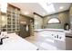 Relaxing bathroom featuring a luxurious soaking tub, a glass block wall, and a skylight at 8220 Traders Hollow Ct, Indianapolis, IN 46278