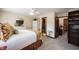 Comfortable bedroom with neutral walls, carpeted floors, a ceiling fan, an ensuite bathroom, and a bookcase at 8220 Traders Hollow Ct, Indianapolis, IN 46278