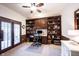 Well-lit home office featuring custom built-in shelving, providing ample storage and display space at 8220 Traders Hollow Ct, Indianapolis, IN 46278