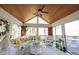Bright sunroom with wood paneled ceiling and a seating area overlooking nature at 8220 Traders Hollow Ct, Indianapolis, IN 46278