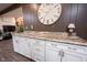 Wet bar featuring modern cabinetry, a granite countertop, a sink, and brushed nickel hardware at 8220 Traders Hollow Ct, Indianapolis, IN 46278