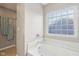 Bright bathroom featuring a large soaking tub with glass block window at 8233 Katrina Way, Fishers, IN 46038