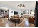 Comfortable living room featuring hardwood floors, a ceiling fan, and large windows for natural light at 8356 W 100 S, Needham, IN 46162