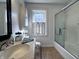 Bright bathroom featuring a tiled floor, shower with glass enclosure, modern fixtures and plenty of counter space at 850 N Butler Ave, Indianapolis, IN 46219