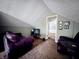Attic living room features a television, comfortable seating, and an adjacent storage area with built-in shelving at 850 N Butler Ave, Indianapolis, IN 46219