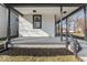 A welcoming covered porch with gray flooring and a modern black railing, providing a charming entry to the home at 866 W 29Th St, Indianapolis, IN 46208