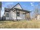 Side view of a quaint home showing off black trim, a covered porch, and tidy landscaping for curb appeal at 866 W 29Th St, Indianapolis, IN 46208