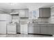 Efficient kitchen featuring gray cabinets and white appliances, creating a clean and functional space at 866 W 29Th St, Indianapolis, IN 46208