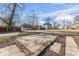 A cracked concrete pad sits in the yard with nearby homes visible in the distance under a bright sky at 866 W 29Th St, Indianapolis, IN 46208