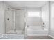 Bathroom featuring a separate shower and tub, with bright natural light from a window at 1040 Arthur Ct, Greenfield, IN 46140