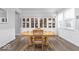 Elegant dining room with a wooden table and chair set, complemented by stylish built-in cabinets and wainscoting at 1040 Arthur Ct, Greenfield, IN 46140