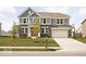 Charming two-story home featuring gray siding, brick accents, landscaped yard, and a basketball hoop above the garage at 1040 Arthur Ct, Greenfield, IN 46140