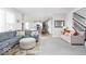 Bright living room featuring hardwood floors, a large sofa, and an open floor plan leading to the kitchen at 1040 Arthur Ct, Greenfield, IN 46140