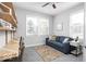 Bright office space with a comfortable blue sofa, built-in shelves, and natural light from the windows at 1040 Arthur Ct, Greenfield, IN 46140