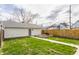Backyard featuring a detached garage and raised garden beds, with well-maintained grass at 1041 S State Ave, Indianapolis, IN 46203