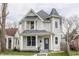 Charming two-story home with Victorian-era architectural details and a freshly landscaped front yard at 1041 S State Ave, Indianapolis, IN 46203
