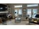 Cozy living room with a brick fireplace, hardwood floors, and comfortable seating with plentiful light at 113 Edgewater Dr, Noblesville, IN 46062