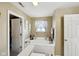 Bathroom with a large soaking tub, window, and a view of the closet area at 11624 Eldridge Dr, Indianapolis, IN 46235