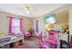 Bright bedroom featuring pink decor, plush carpeting, and a ceiling fan at 11624 Eldridge Dr, Indianapolis, IN 46235
