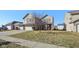 Well-maintained two-story home with three-car garage, green lawn and sidewalk at 11624 Eldridge Dr, Indianapolis, IN 46235